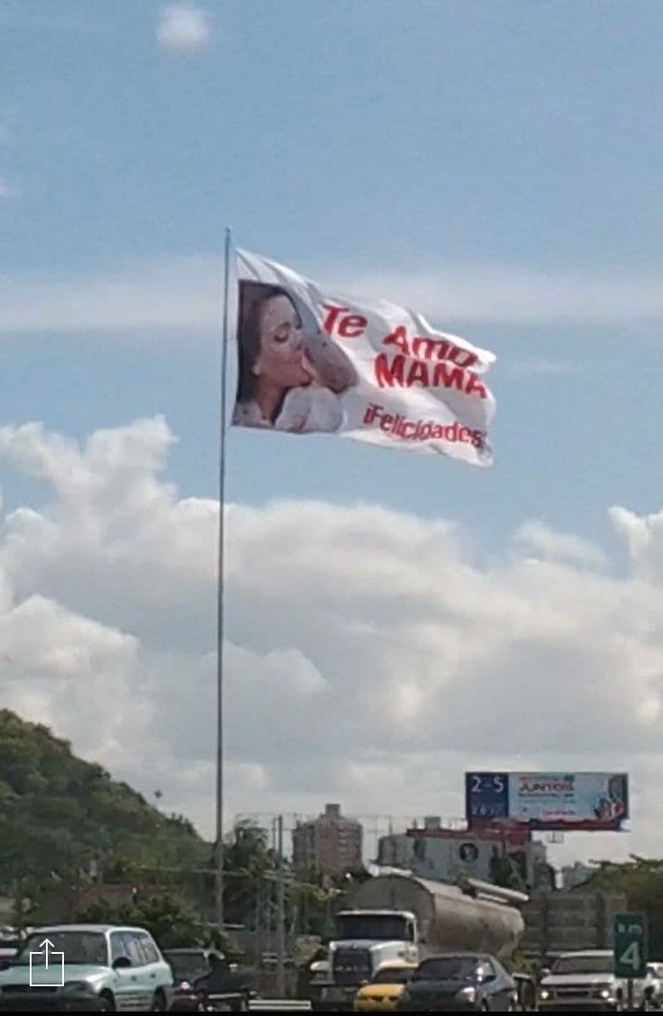 Bandera "Te Amo Mamá" en asta de cien pies sobre la autopista.